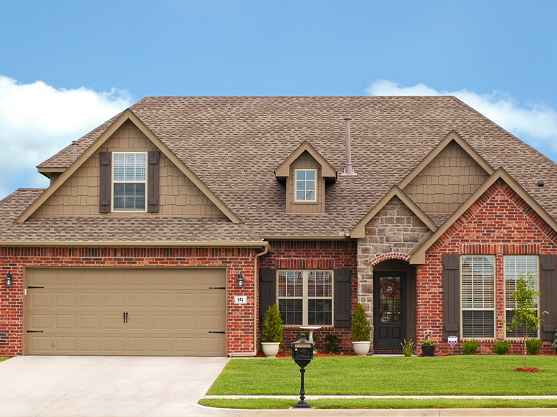 a large brick building with grass in front of a house